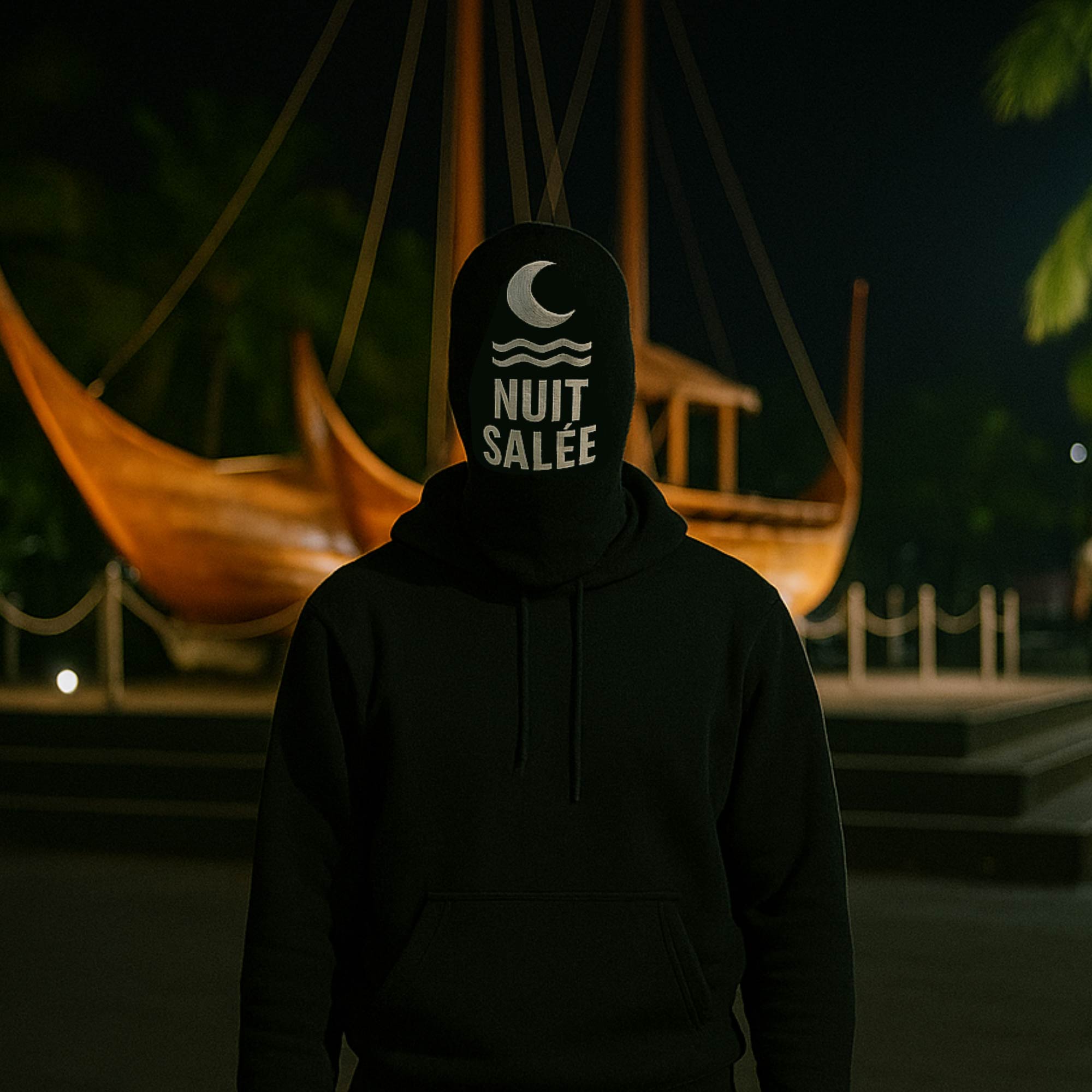 Nuit Salée in front of a sailing canoe at night